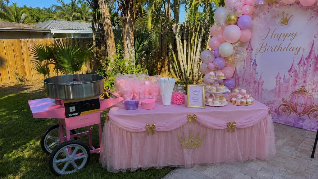 The Cotton Candy Social pink cotton candy cart set up for a princess-themed backyard birthday party